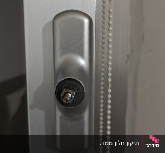 ידית מתכת על תריס עם שרשרת פלסטיק לבנה